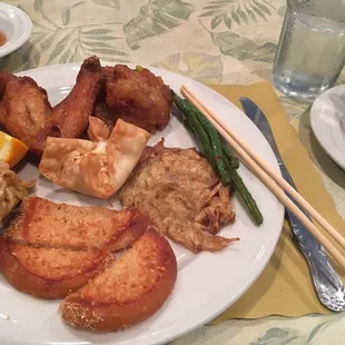 a plate of food with chopsticks and a cup of tea