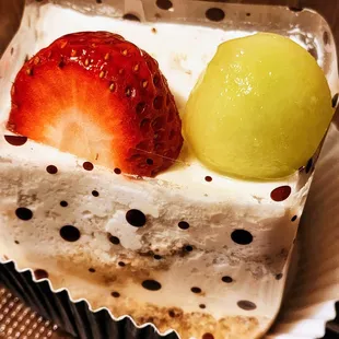 a piece of cake with strawberries and a lemon