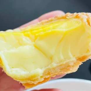 a person holding a pastry with a bite taken out of it