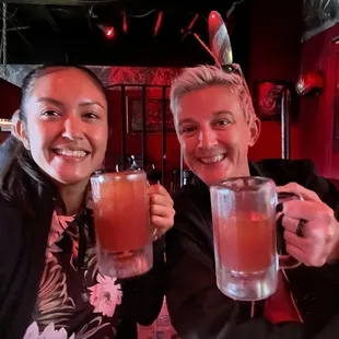 two people holding up drinks