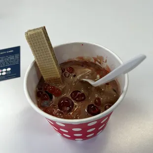 a cup of ice cream with a wafer sticking out of it