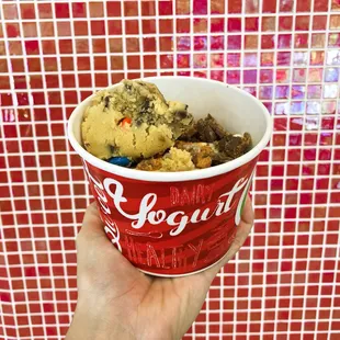 a hand holding a cup of ice cream