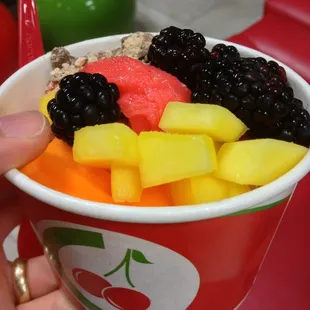 a person holding a cup of fruit