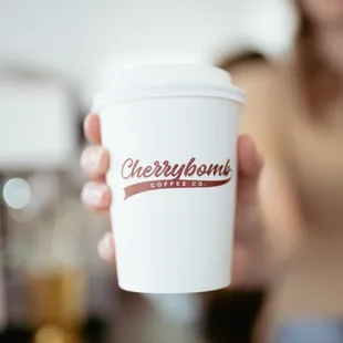 a woman holding a cup of coffee