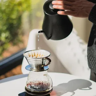 a person pouring a cup of coffee
