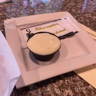 a bowl of sauce on a plate