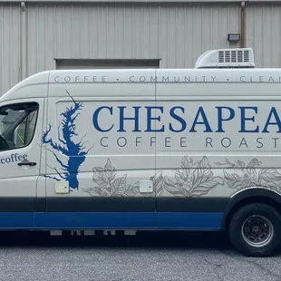 a coffee roaster van parked in front of a building