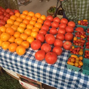 a table of tomatoes and oranges