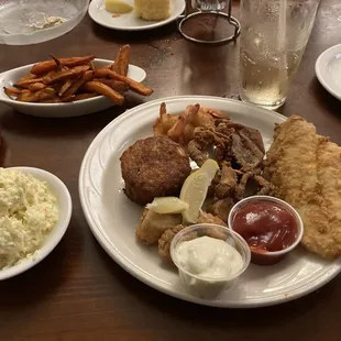 Fried seafood platter with sweet potato fries and Cole slaw.