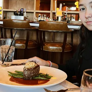 a woman sitting at a table with a plate of food