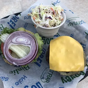 Absolutely amazing burger on a gluten-free bun with a side of coleslaw and a glass of Chardonnay.