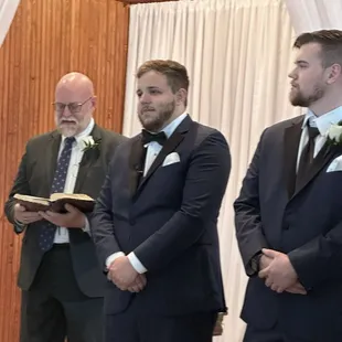 Pastor, groom, best man front of chapel