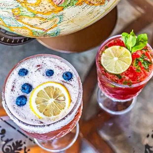 two cocktails with a globe in the background
