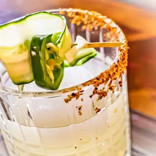 a cucumber garnish on a cocktail glass