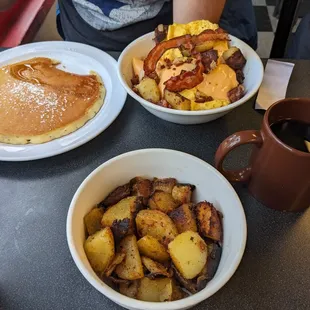 Pancake, side of home fries, coffee, and bowl