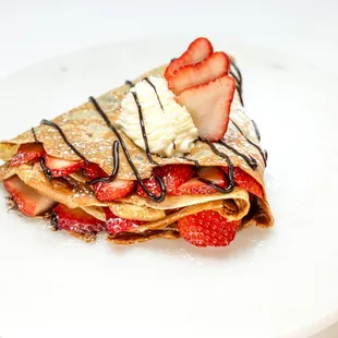 a crepe with strawberries and whipped cream