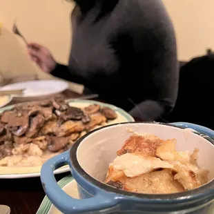 a woman sitting at a table with plates of food