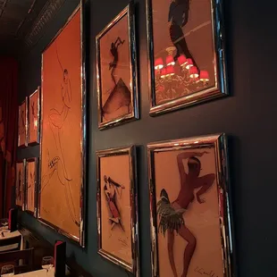 a wall of paintings in a restaurant