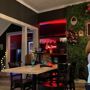 a dining room with a bar in the background