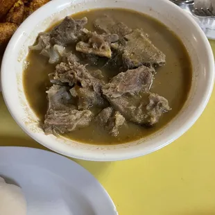 a bowl of soup with meat and potatoes