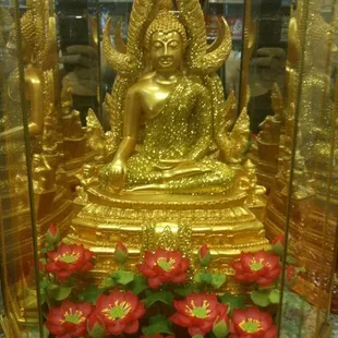 a gold statue in a glass case