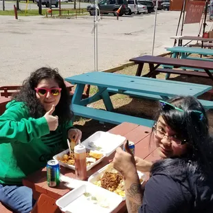 two people eating at a picnic table