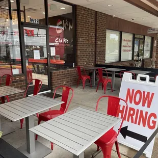a now hiring sign in front of a restaurant