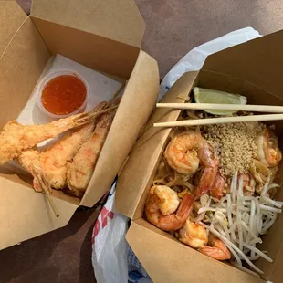 two boxes of food with chopsticks in them