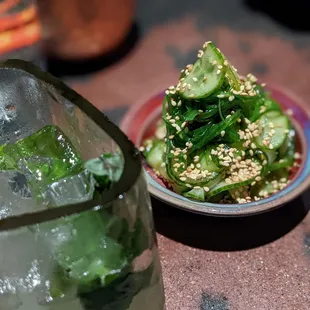 a bowl of cucumbers and a glass of water