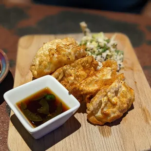 a plate of fried food and a small bowl of sauce