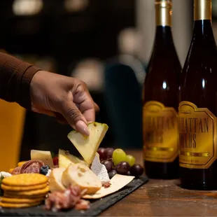 a person putting cheese on a cheese board