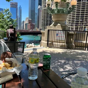 a man sitting at a table with a view of the chicago river