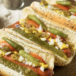 three hotdogs with toppings