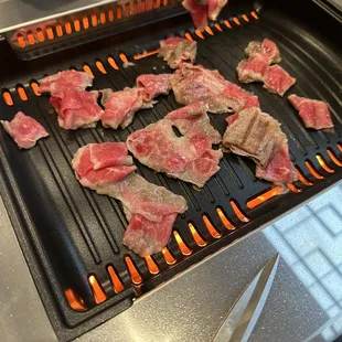 steaks being cooked on a grill