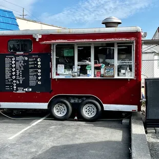 a red food truck parked in a parking lot