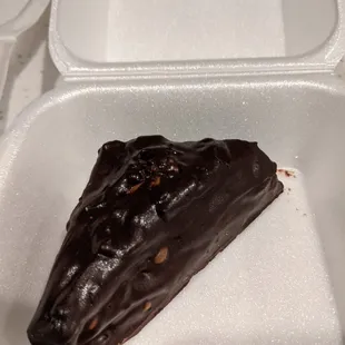 a piece of chocolate cake in a styrofoam container