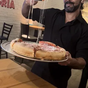 a man holding a pizza