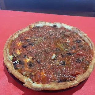 a chicago style pizza on a red tablecloth