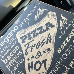 a pizza box sitting on the back of a car