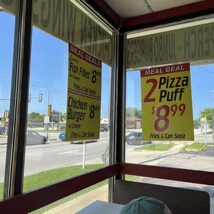 two pizzas and a hat on a table in front of a window