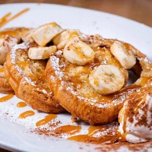 a plate of french toast with bananas and ice cream