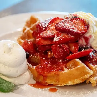 a waffle with strawberries and ice cream