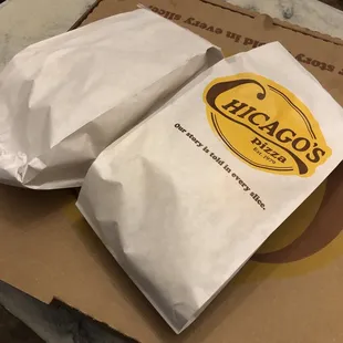 two bags of pizza on a table