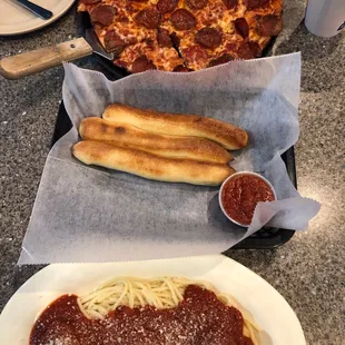 Spaghetti Bowl with breadsticks and a thin crust pepperoni pizza