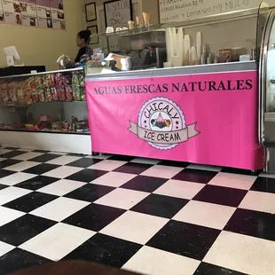 a black and white checkered floor with a pink banner