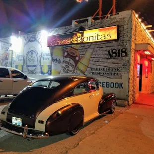 a classic car parked in front of a restaurant