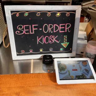 a self order sign and a tablet