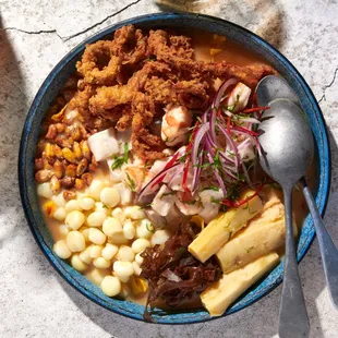 a bowl of mexican food and a glass of beer
