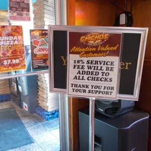 Here is where it is very prominently displayed that an 18% tip (or service fee) will be added to your tab.  At least they tell you.