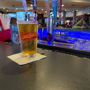 a glass of beer on a bar